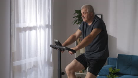 adult-man-is-losing-weight-training-on-exercycle-in-home-sport-activity-at-self-isolation-at-pandemic-healthy-lifestyle